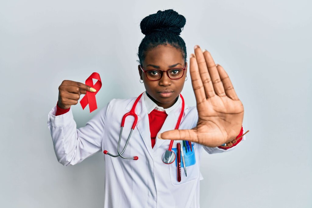 Doctor holding a red ribbon symbolizing HIV awareness.