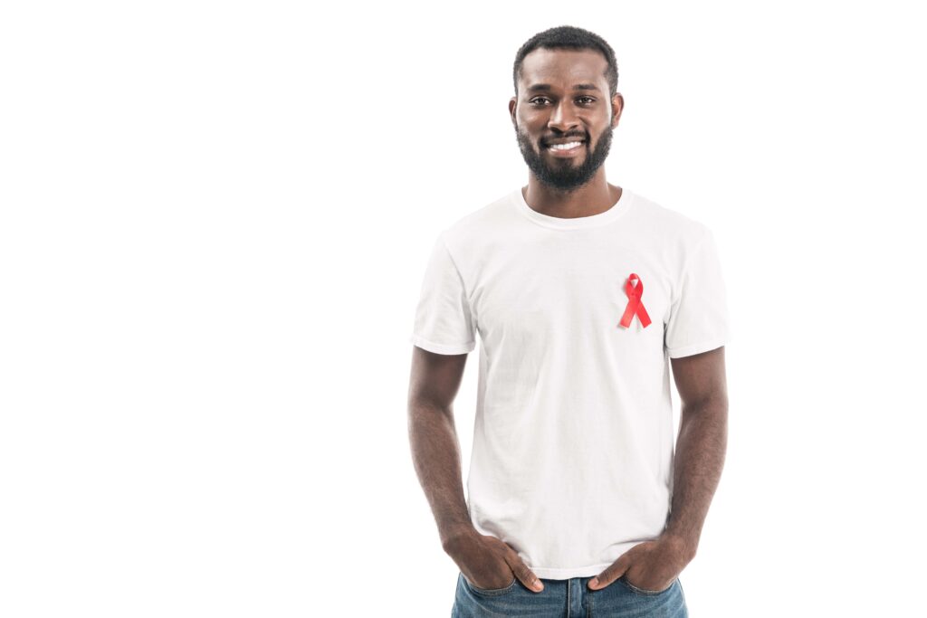 African-American man wearing a white t-shirt with a red ribbon symbolizing HIV/AIDS awareness