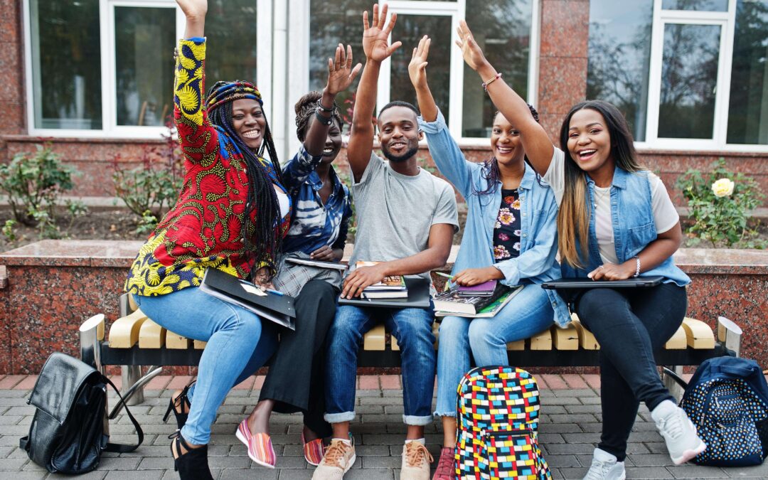 A group of young adults raising their arms together.